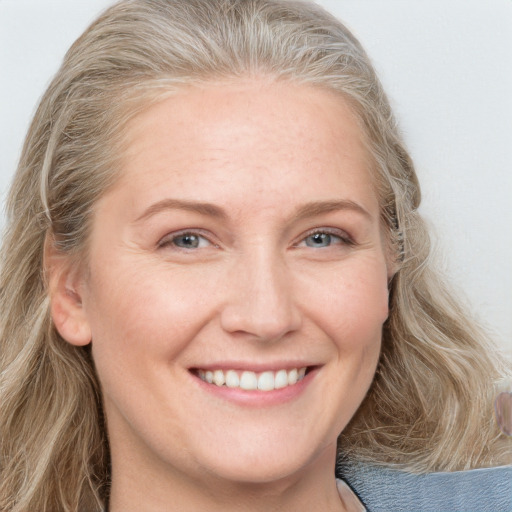 Joyful white adult female with long  brown hair and blue eyes