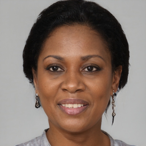 Joyful black adult female with medium  brown hair and brown eyes