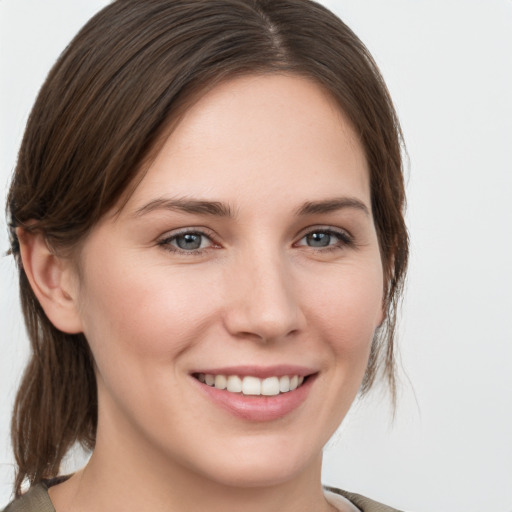 Joyful white young-adult female with medium  brown hair and grey eyes