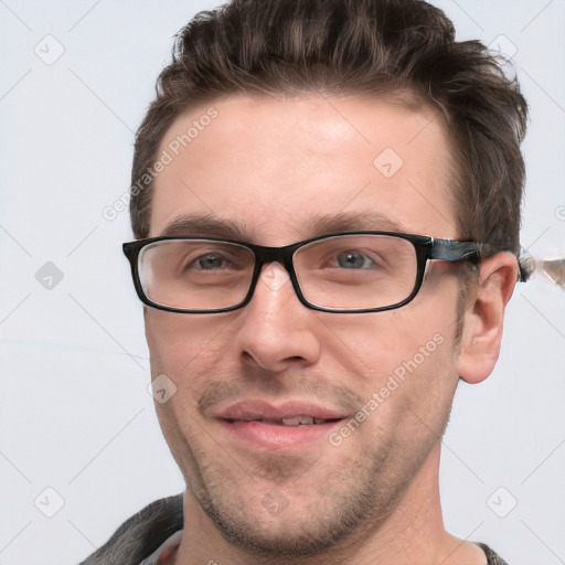 Joyful white adult male with short  brown hair and blue eyes