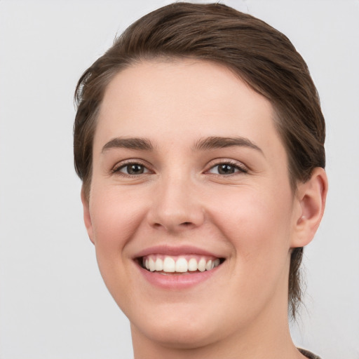 Joyful white young-adult female with short  brown hair and grey eyes