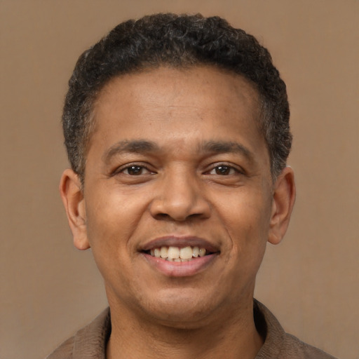 Joyful latino young-adult male with short  brown hair and brown eyes
