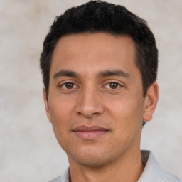 Joyful latino young-adult male with short  black hair and brown eyes