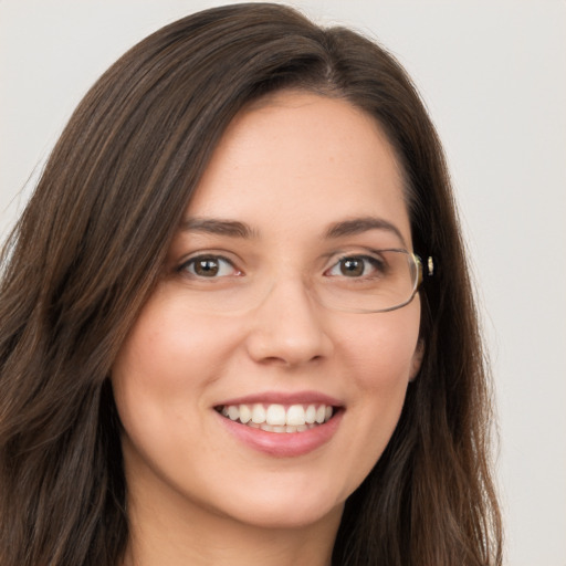 Joyful white young-adult female with long  brown hair and green eyes