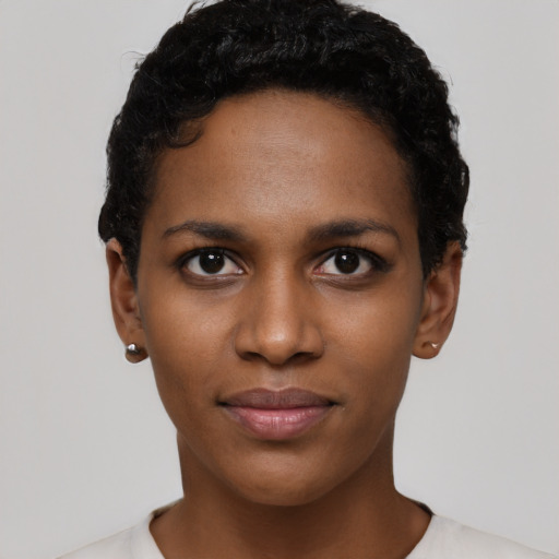 Joyful black young-adult female with short  black hair and brown eyes