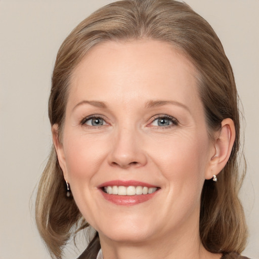 Joyful white adult female with medium  brown hair and grey eyes