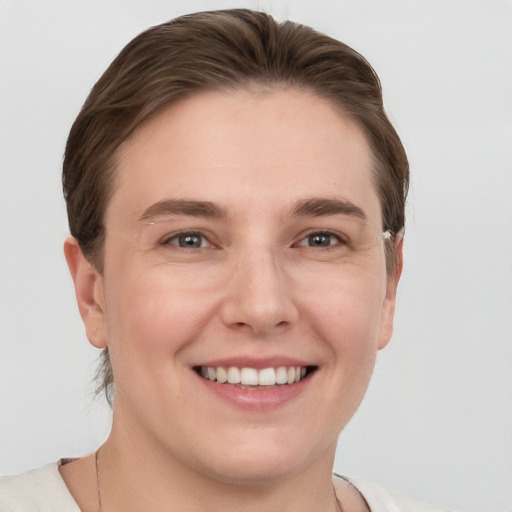 Joyful white young-adult female with short  brown hair and grey eyes