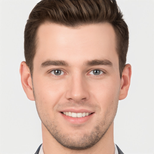 Joyful white young-adult male with short  brown hair and grey eyes