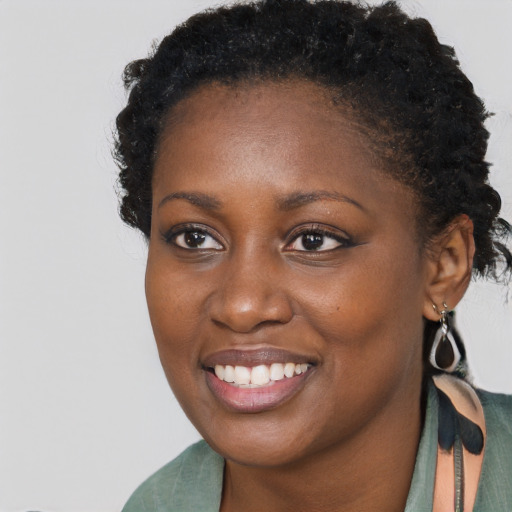 Joyful black young-adult female with long  brown hair and brown eyes