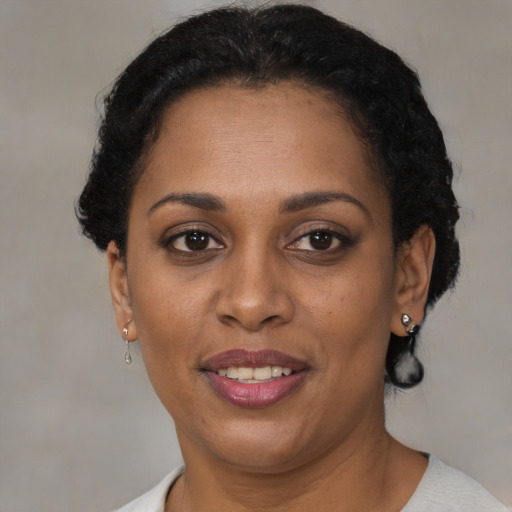 Joyful black adult female with short  brown hair and brown eyes