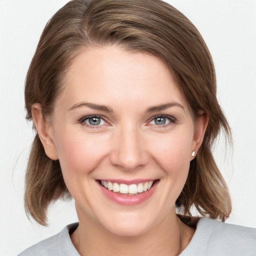 Joyful white young-adult female with medium  brown hair and grey eyes