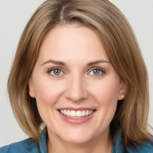 Joyful white young-adult female with medium  brown hair and blue eyes