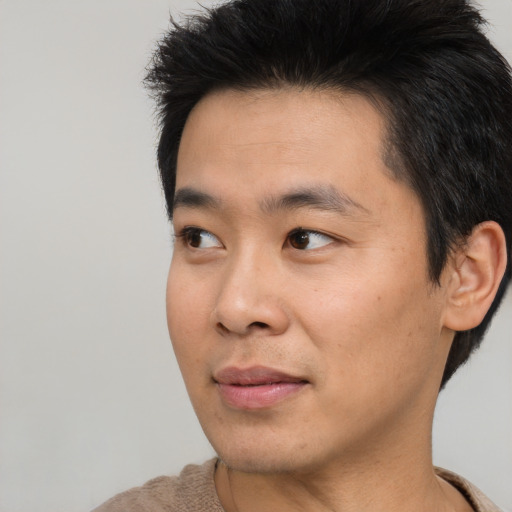 Joyful asian young-adult male with short  brown hair and brown eyes