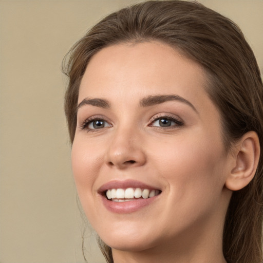 Joyful white young-adult female with long  brown hair and green eyes