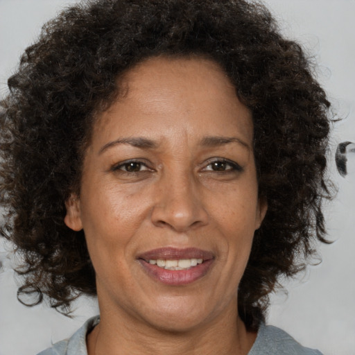 Joyful black adult female with medium  brown hair and brown eyes
