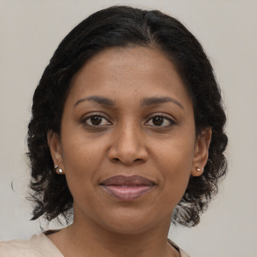Joyful black adult female with medium  brown hair and brown eyes