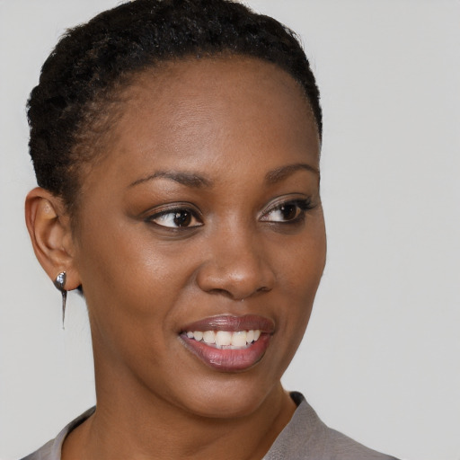 Joyful black young-adult female with short  brown hair and brown eyes