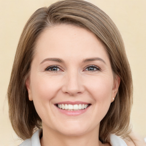 Joyful white young-adult female with medium  brown hair and green eyes