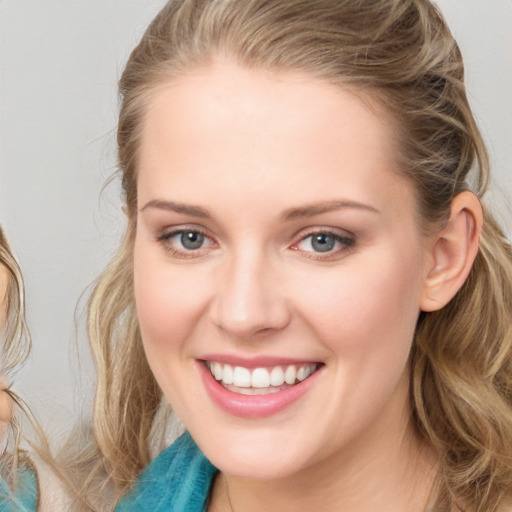 Joyful white young-adult female with long  brown hair and blue eyes