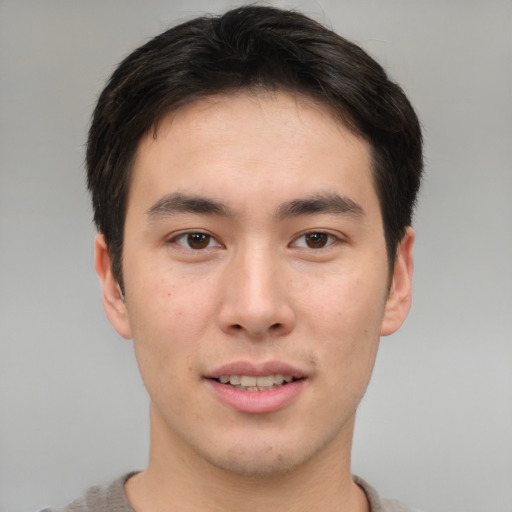 Joyful asian young-adult male with short  brown hair and brown eyes