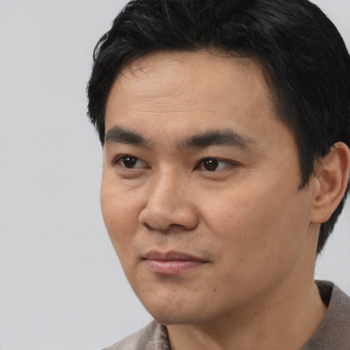 Joyful asian young-adult male with short  black hair and brown eyes