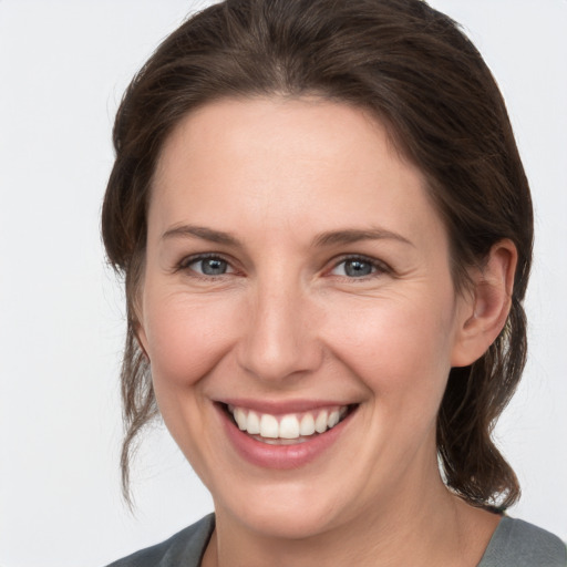 Joyful white young-adult female with medium  brown hair and grey eyes