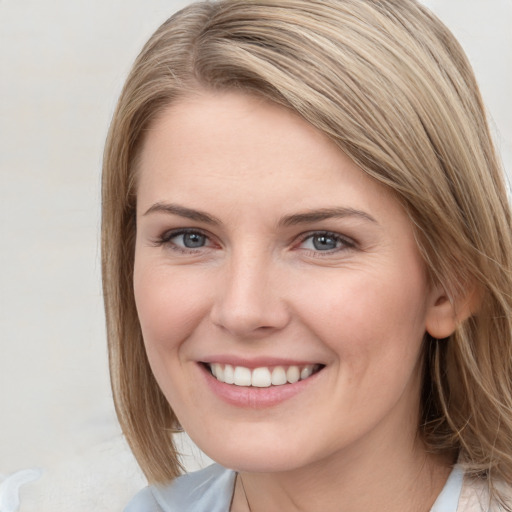 Joyful white young-adult female with long  brown hair and blue eyes