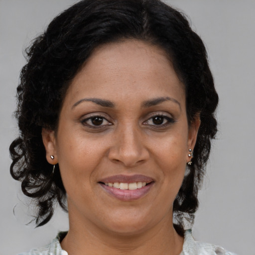 Joyful black adult female with medium  brown hair and brown eyes
