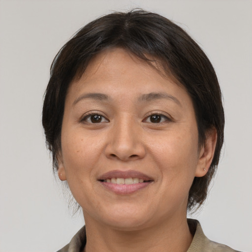 Joyful asian adult female with medium  brown hair and brown eyes