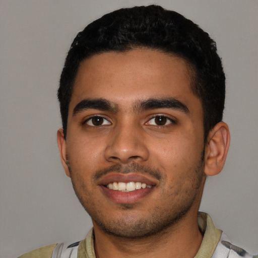 Joyful latino young-adult male with short  black hair and brown eyes