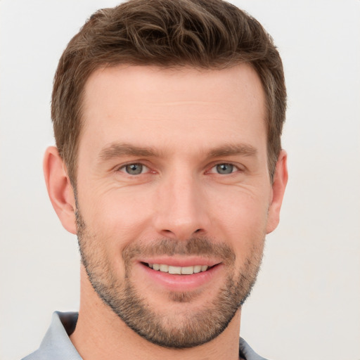 Joyful white young-adult male with short  brown hair and grey eyes