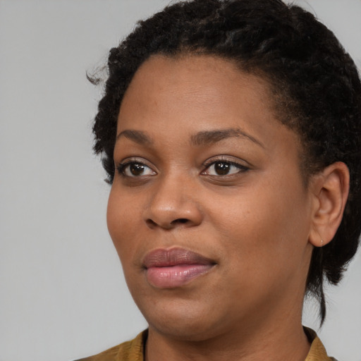 Joyful black young-adult female with medium  brown hair and brown eyes