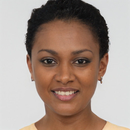 Joyful black young-adult female with short  black hair and brown eyes