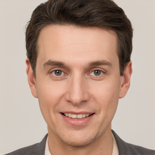 Joyful white adult male with short  brown hair and grey eyes