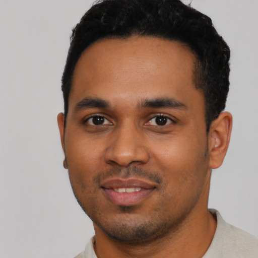 Joyful black young-adult male with short  black hair and brown eyes