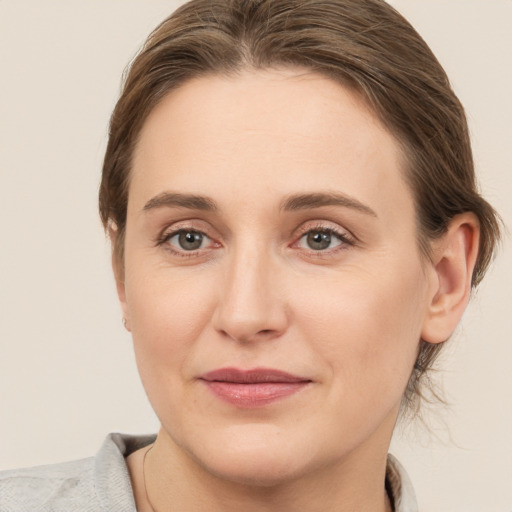 Joyful white young-adult female with medium  brown hair and grey eyes