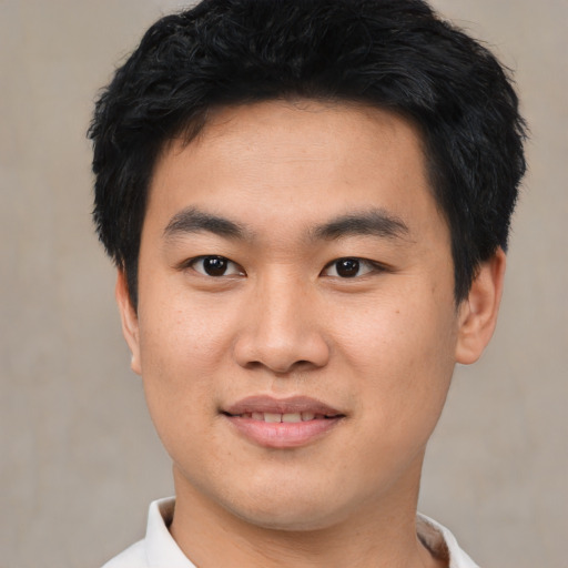 Joyful asian young-adult male with short  black hair and brown eyes