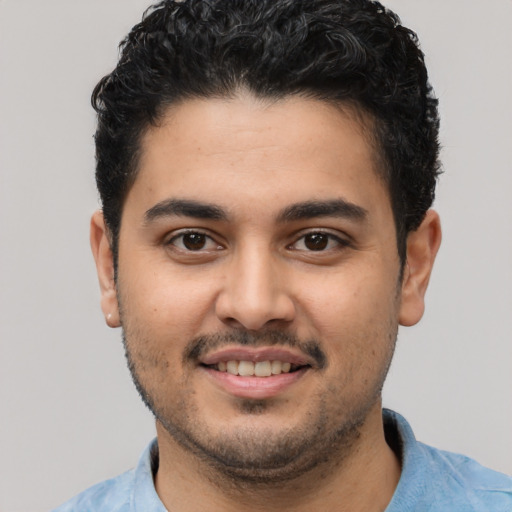 Joyful latino young-adult male with short  black hair and brown eyes