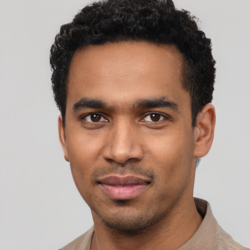 Joyful black young-adult male with short  black hair and brown eyes
