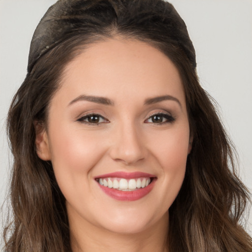 Joyful white young-adult female with long  brown hair and brown eyes