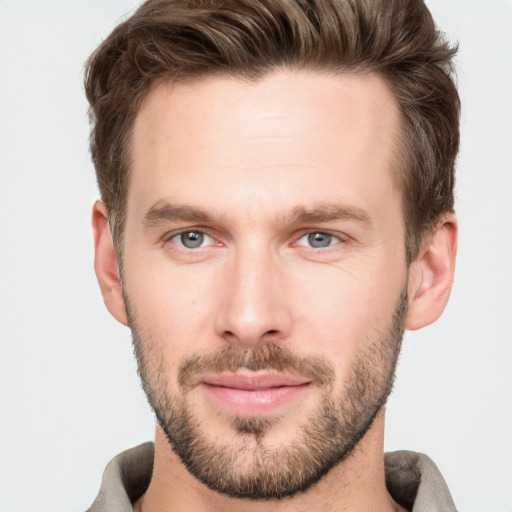 Joyful white young-adult male with short  brown hair and grey eyes