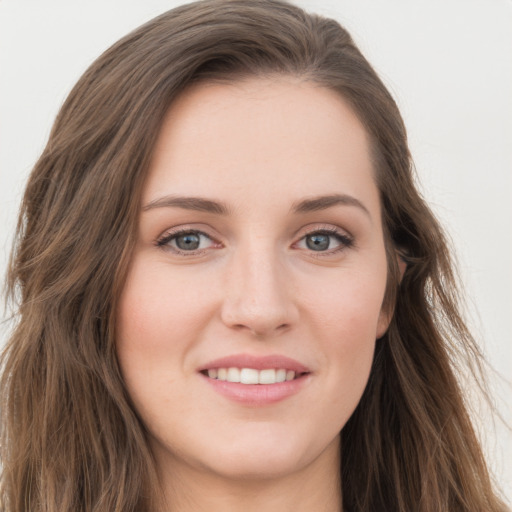 Joyful white young-adult female with long  brown hair and blue eyes