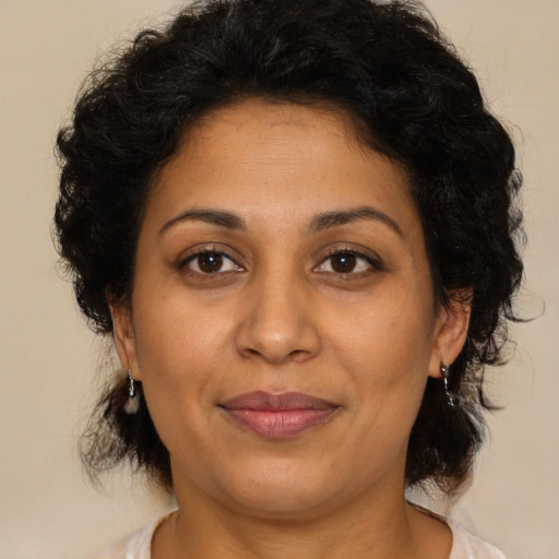 Joyful latino adult female with medium  brown hair and brown eyes