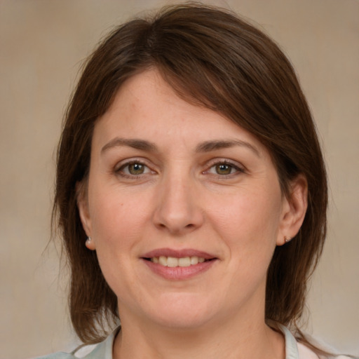 Joyful white adult female with medium  brown hair and grey eyes