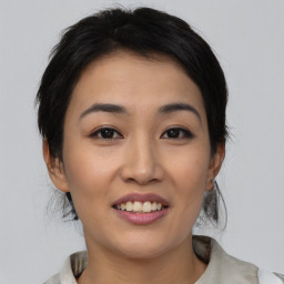 Joyful asian young-adult female with medium  black hair and brown eyes