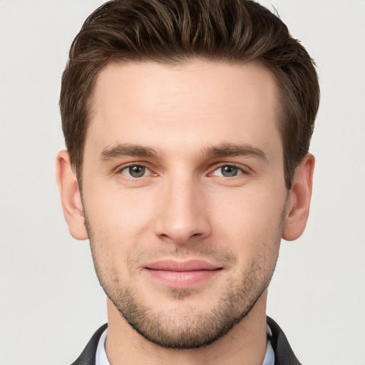 Joyful white young-adult male with short  brown hair and grey eyes