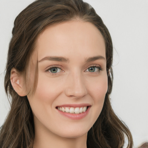 Joyful white young-adult female with long  brown hair and green eyes