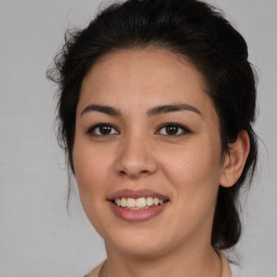 Joyful latino young-adult female with medium  brown hair and brown eyes