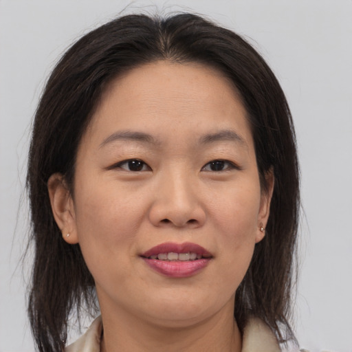 Joyful asian adult female with medium  brown hair and brown eyes