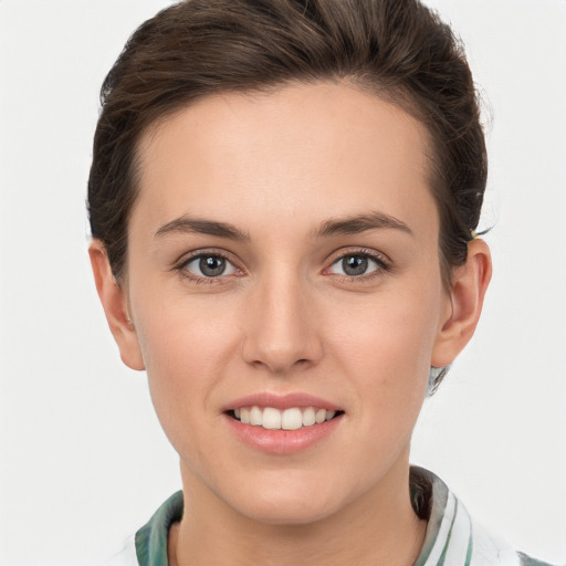 Joyful white young-adult female with short  brown hair and grey eyes